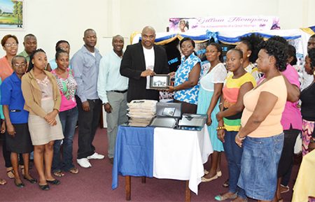 Chief Executive Officer of Southern Systems Karl Moore (tenth, left) hands over the donation in the presence of library staff and Thompson’s family.