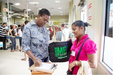 A shopper signing a pledge to use the bag (Guyenterprise photo) 