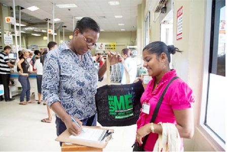 A shopper signing a pledge to use the bag (Guyenterprise photo)

