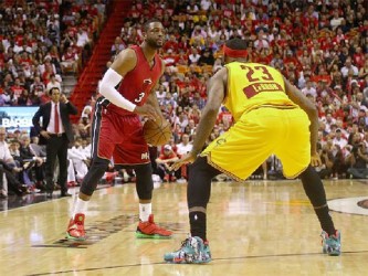 Dwyane Wade, with ball being challenged by former teammate LeBron James of the Cleveland Cavaliers in their Christmas Day matchup at American Airlines Arena which the Heat won with Wade scoring 31 points and James 30 for Cleveland. 