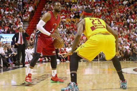 Dwyane Wade, with ball being challenged by former teammate LeBron James of the Cleveland Cavaliers in their Christmas Day matchup at American Airlines Arena which the Heat won with Wade scoring 31 points and James 30 for Cleveland.
