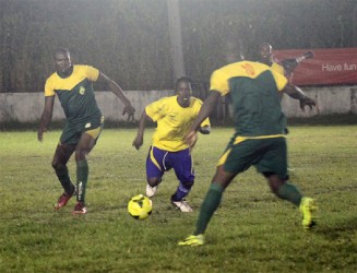 Pele’s Omallo Williams  tries to split two GDF midfielders to get to the ball. (Orlando Charles photo) 