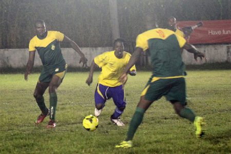 Pele’s Omallo Williams  tries to split two GDF midfielders to get to the ball. (Orlando Charles photo)
