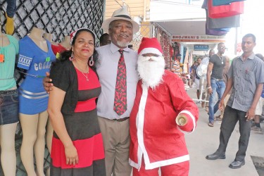 Prime Minister Samuel Hinds (centre) posing with Santa today on Regent Street.