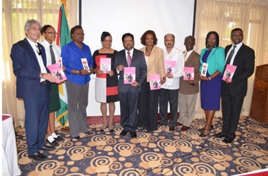 From left are Roberto Campos, UNAIDS Country Director; Chelsea Edghill of Bishops’ High School; UNICEF Representative, Cornelly McAlmont; Director of Maternal and Child Health, Dr. Janice Woolford; Minister of Finance, Dr. Ashni Singh; UN Resident Coordinator Khadija Musa; Minister Health, Dr Bheri Ramsaran; PAHO/WHO, Representative, William Adu-Krow; UNFPA Representative, Patrice LaFleur,  and Chief Medical Officer, Dr. Shamdeo Persaud with a copy of Guyana's MDG Acceleration Framework and Campaign to improve Maternal Health (GINA photo)