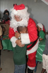 Santa hugging  a child at today’s annual party at the Dharm Shala in Albouystown for children.