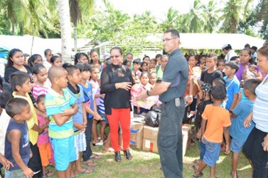 Minister of Amerindian Affairs Pauline Sukhai presents gifts for the children to Father Marina (GINA photo)