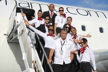 Local representative of Dynamic Airways Captain Gerry Gouveia (left at front) with some of the flight attendants on the stairway of the aircraft which departed at 5 pm yesterday. (See page 3)
