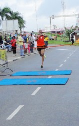 Lionel D’ Andrade is all alone as he crosses the finish line in the 5K race on Sunday in Paramaribo.