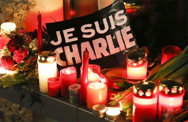 Candles and a placard which reads “I am Charlie” are pictured as tributes to victims at the French embassy at Pariser Platz in Berlin January 7, 2015, following a shooting by gunmen at the offices of weekly satirical magazine Charlie Hebdo in Paris. REUTERS/Fabrizio Bensch