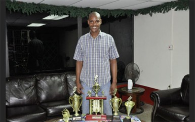 Organiser Lyall Gittens display the trophies up for grabs this Sunday in the August Beverages/ Untouchable Boss dominoes tournament.      