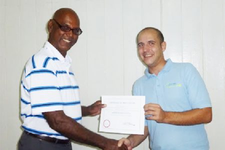Rice farmer Humberto Hamilton (left) receiving his certification after a recent seminar. 