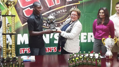 Domini Garnett (left) of Grove Hi-Tech receiving the most valuable player accolade from ANSA McAl Managing Director Beverly Harper after successfully leading his team to the championship