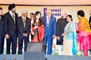 President Donald Ramotar shares a light moment with Sushma Swaraj, External Affairs Minister of India following the ceremony where he was bestowed with the Pravasi Bharatiya Samman Award on Friday. Also on stage is India’s Vice President, Mohammad Hamid Ansari (at right). (Government Information Agency photo)