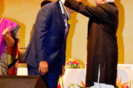 India’s Vice President, Mohammed Hamid Ansari, decorating President Donald Ramotar with the Pravasi Bharatiya Samman medal. (Government Information Agency photo)