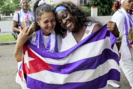 Recently released dissidents Aide Gallardo (L) and Sonia Garro hold the Cuban national flag during a march in Havana January 11, 2015. (Reuters/ Stringer)