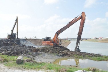 An excavator completing the tying of the embankment to the bridge and the high level discharge sluice of the Hope Canal. (Government Information Agency photo) 
