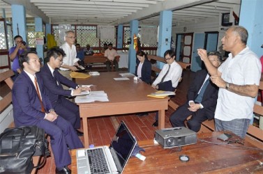 Agriculture Minister Dr. Leslie Ramsammy in a brief discussion with the Japanese Vice-Foreign Minister Takashi Uto and team during a visit to the Northern Relief Channel at the Hope Canal, East Coast Demerara last Friday. (Government Information Agency photo)