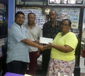 Faizal Ally (left), Managing Director of A. Ally and Sons presents a sponsorship cheque to BCB Secretary Angela Haniff, as Competition Committee Chair Carl Moore and Leslie Solomon look on. 