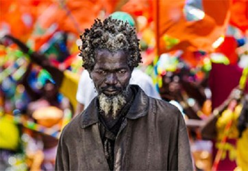 The award winning photo taken by Fidal Bassier. The vagrant’s eyes are sad and lost, the rough texture of his  hair and beard jump out of the photo. The bleak colour of his clothing and his hair texture really contrast with the vibrancy in the background. 