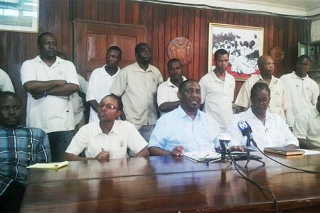 GPSU President Patrick Yarde, sitting at centre, speaking during the press conference on Friday, in the presence of GPSU officials and GGMC workers on strike.
