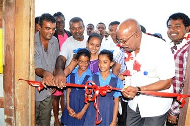 Minister of Local Government & Regional Development , Norman Whittaker (second from right) along with beneficiaries, and officials cutting the ribbon to commission the Friendship swine  facility (GINA photo) 