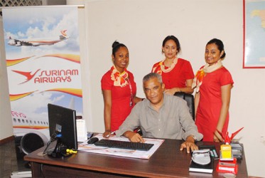 Going great guns: Suriname Airways Station Manager (Guyana) Rudi Westerborg with staff members in the company’s Kingston office on Wednesday 