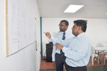 Finance Minister, Dr. Ashni Singh (right) seeks clarification from Ian Ramdeo, Director of the company developing the Giftland mall, on the facility’s plan on Wednesday (GINA photo)