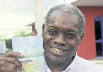 An elated Lloyd Bogle displays his multi-entry visa in his passport at the Jamaica Observer yesterday evening. (Photo: Bryan Cummings/ Jamaica Observer)