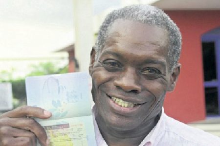 An elated Lloyd Bogle displays his multi-entry visa in his passport at the Jamaica Observer yesterday evening. (Photo: Bryan Cummings/ Jamaica Observer)