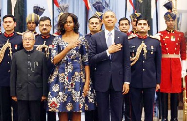 U.S. President Barack Obama and first lady Michelle Obama hold their hands over their hearts during the playing of the U.S. National Anthem at a receiving line with India’s President Pranab Mukherjee (front L) before the start of an official Indian State Dinner for Obama at the Rashtrapati Bhavan presidential palace in New Delhi January 25, 2015. Reuters/Jim Bourg