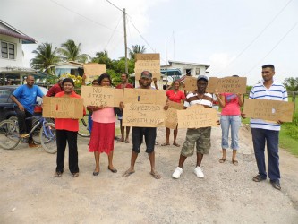 The residents holding their placards in front of the Canefield/Enterprise NDC office in East Canje Berbice 