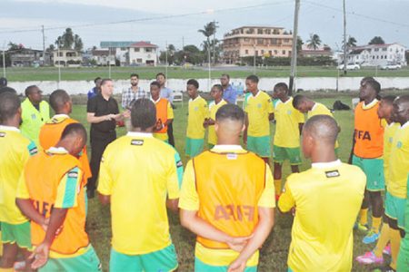 GFF Technical Director Claude Bolton addressing the Golden Jaguars senior side prior to the commencement of their final local training session at the Guyana Defence Force ground