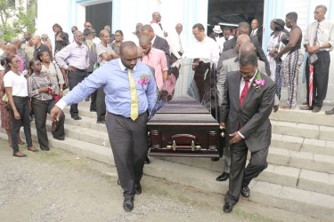 Patrick Harding and his son Patrick Jnr lead the pallbearers carrying Faith Harding’s casket out of Christ Church yesterday. (Photo by Arian Browne) 