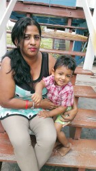 Farida Persaud and her son sitting on their front step. 