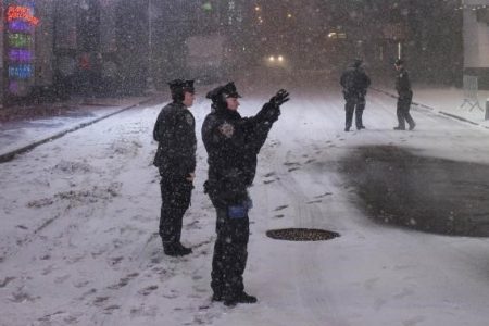 An New York Police Department officer takes photographs while keeping security during a snowstorm in Times Square, New York early morning January 27, 2015.Credit: Reuters/Adrees Latif