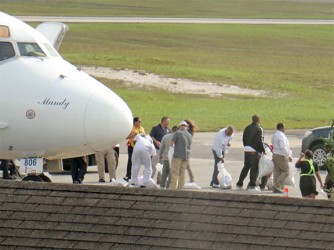 Some of the deportees changing their clothing on the tarmac 