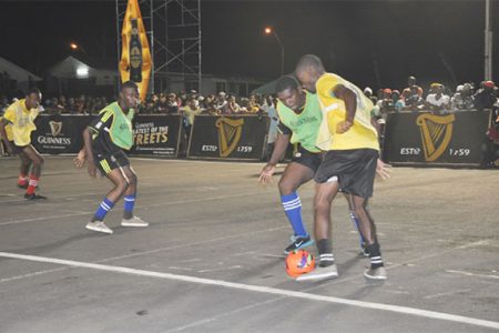 Dexroy Adams (right) of Pouderoyen Showstoppers attempting to maintain possession of the ball while being challenged by Kelvin Roberts of Patentia Street Ballers during their team’s semi-final showdown