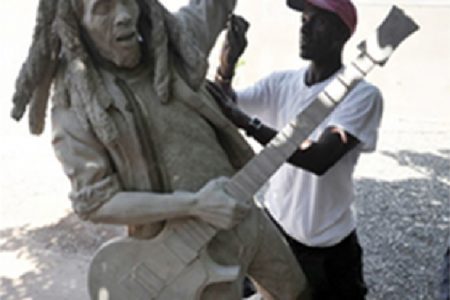 Osmond Watson sanding down the new, unfinished life-size statue of the late reggae super star Bob Marley at the Trench Town Culture Yard in Kingston on Thursday. Sculpted by Scheed Cole, the completed statue will be unveiled tomorrow. Cole was commissioned to do the statue in late December last year to replace the old one. 