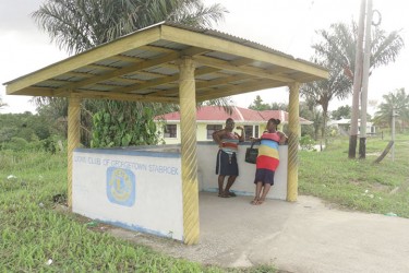 Waiting for transportation in a bus shed built by the Lions Club of Georgetown Stabroek 
