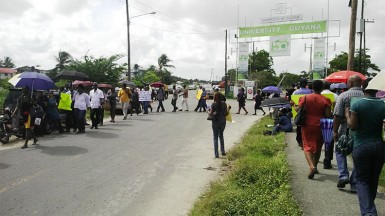 UG staff circling the entrance to the University of Guyana Turkeyen Campus yesterday at the start of a three-day strike.