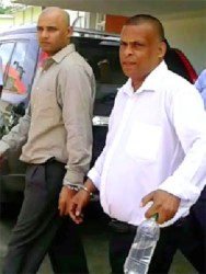 The two accused being escorted from court. From right are Dharmraj Persaud, 41, and Yougeshwar Dhanaram, 32. 