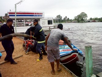 Firemen loading a pump into a boat to take it over to the trawler 