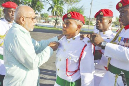 Commander- in-Chief, President Donald Ramotar (left) and Chief of Staff, Brigadier Mark Phillips pinning on the badge of rank of newly commissioned 99921 Second Lieutenant (2Lt) Lewins Langellier (GINA photo)