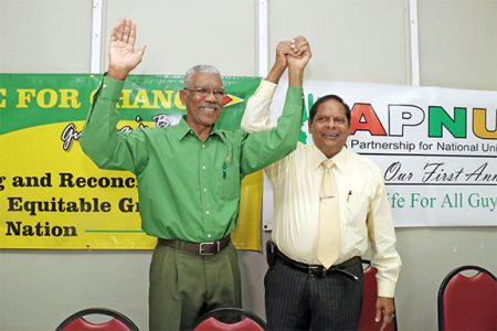 APNU’s David Granger (left) and AFC’s Moses Nagamootoo, presidential and prime ministerial candidates of the new coalition, raise joined hands after the announcement yesterday at the Georgetown Club, Camp Street. (Photo by Arian Browne)