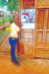 GWMO member Amanda Peters stands next to an anti-human trafficking poster she had just placed on a shop door in Mahdia. 