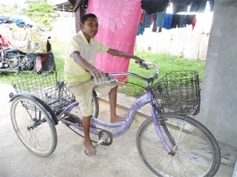 A lad prepping his three wheeler to take it for an afternoon spin