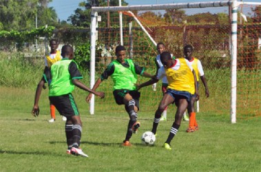 North Ruimveldt’s Matthew Harrison (centre/green) trying to win possession of the ball from a Charlestown player inside the penalty box during their matchup. 