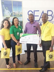 President of the GTTA, Godfrey Munroe smiling after receiving Fly Jamaica’s sponsorship package from Marketing Manager, Nadine Hing. 