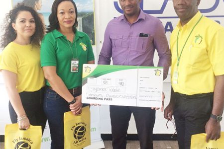 President of the GTTA, Godfrey Munroe smiling after receiving Fly Jamaica’s sponsorship package from Marketing Manager, Nadine Hing.
